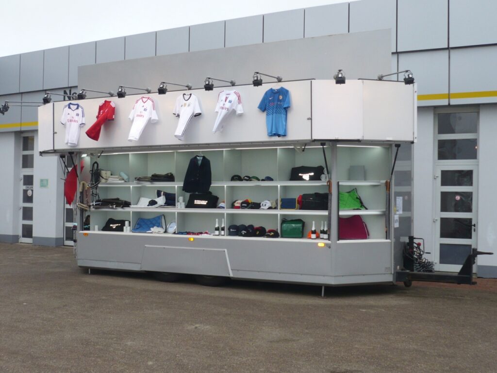 Anhänger in 6 - Eck-Form mit elektrisch aufstellbarem Reklameschild und Regalsystem zum Aussenverkauf. Umfangreiche Lagermöglichkeiten im Innenraum: 3 Etagen Regalböden. 650 / 450 / 450 mm Tiefe, Rückfahrkamera am Anhänger.--Das Fahrzeug hat keinen TÜV (ohne gültige Hauptuntersuchung), daher erfolgt der Verkauf zum Sonderpreis im aktuellen Zustand.-Instandsetzungsarbeiten nur gegen Aufpreis.