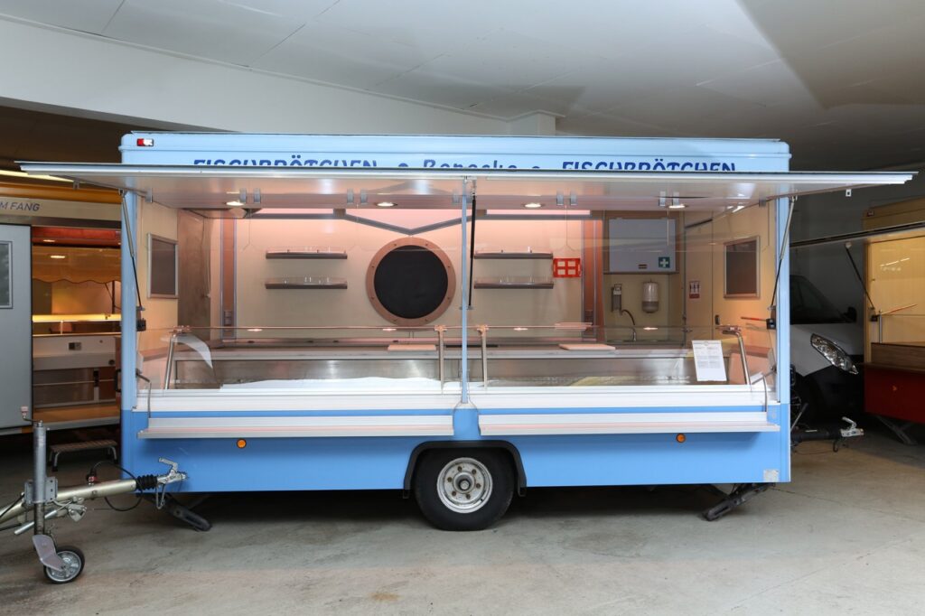 Fisch-Verkaufsanhänger mit Panorama-Kühltheke und Bäro-Beleuchtung sowie Dunstabzugshaube.-Instandsetzungs- und Umbauarbeiten gegen Aufpreis möglich--Der Verkauf erfolgt im Kundenauftrag.