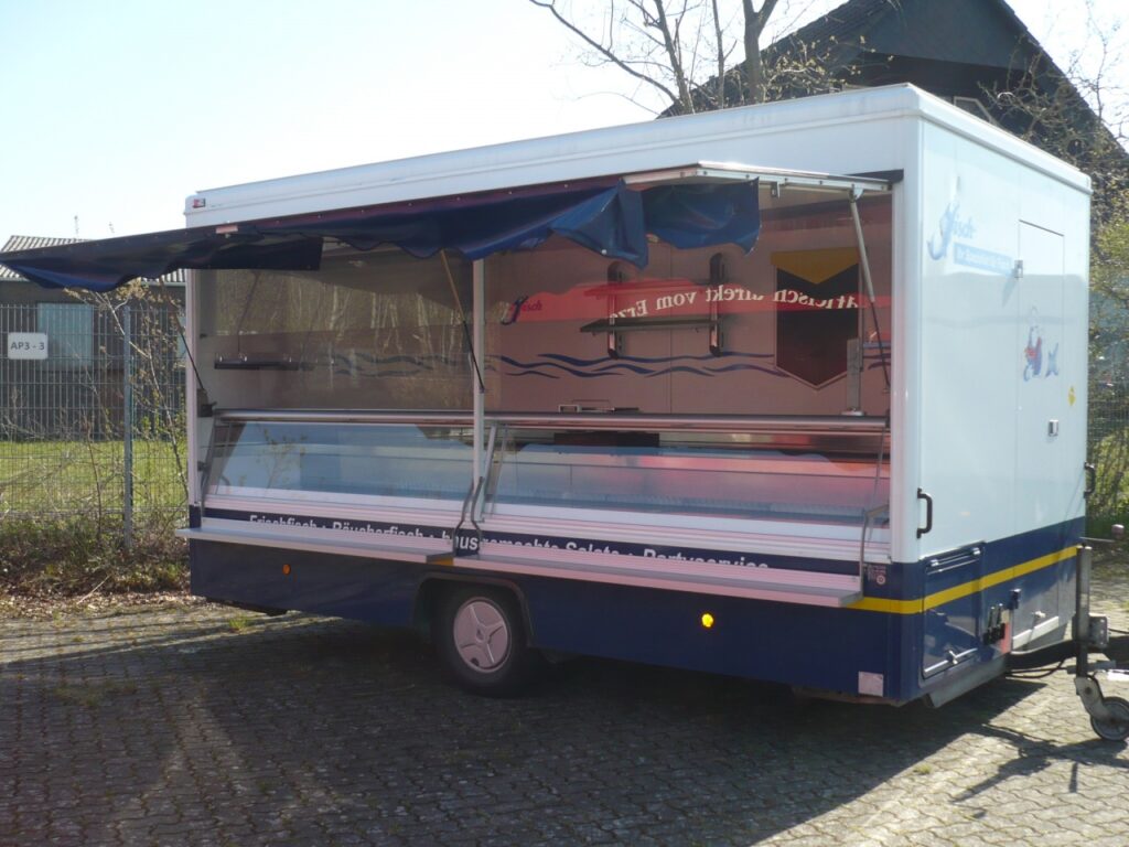 Fischverkaufsanhänger mit 4,50m Kühltheke mit Kühlfach.-Ausstattungsdetails: Thekenarbeitsfläche aus Edelstahl, 2 Borde an Stirn und Heckseite.