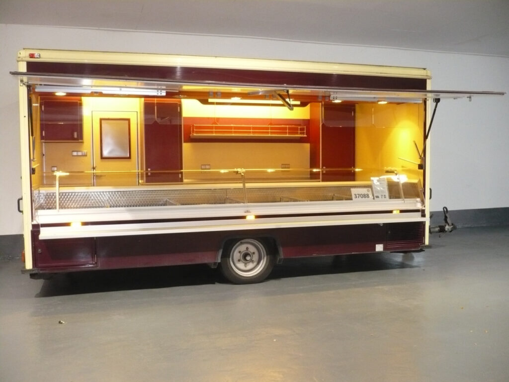 Feinkostverkaufsanhänger mit 5,00 m Edelstahl-Kühltheke 905 mm Thekenauslage mit Kontaktkühlung, verstärkte Kühlleistung,  5 Kühlfächer unter Theke, Edelstahlgestelle für GN-Behälter in der Thekenauslage, passend für 3 x 1/2 GN hintereinander. Heißgasabtauautomatik, Digitalsteuerung und beheizter Verdampferrinne, Kabeltrommel mit 25 m Kabel für 400 V-Anschluß, beheizte Körperschutzkante, Warmluftheizung uvm.