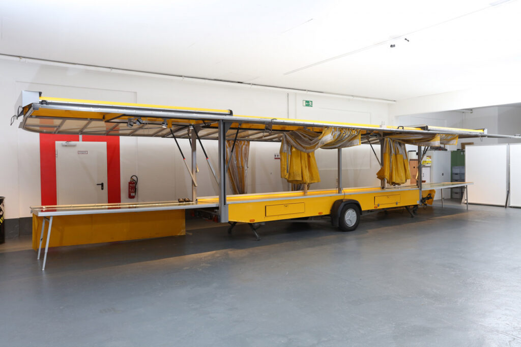 Obst & Gemüse Verkaufsanhänger Typ: SPEWI  von 6,00 auf 12,00 m ausziehbar, Windschutzvorhang am kompletten Anhänger, Schürze an Verkaufsseite, Schubalde und Karosserieklappe als Stauraum. LED-Aufbaustrahler.