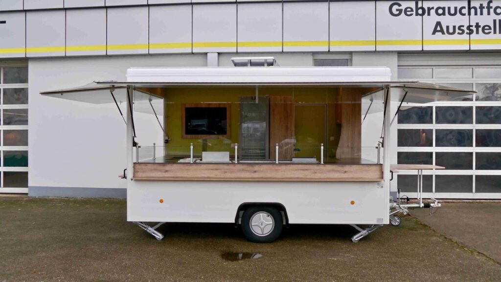 hochwertiger Verkaufsanhänger mit folgender Ausstattung:-- zusätzliche Verkaufsseite-- Esstisch & Essbrett-- 3 Imbissgeräte:-     Bratgerät 1400 mm UBERT-     2-Korb-Friteuse KF 402 UBERT-     Bainmarie BM WBG UBERT-- 2 Kühlschränke:-     LIEBHERR FKU 1800 180 Liter-     LIEBHERR FKvsl 3613 348 Liter mit Isolierglastür sowie-     LED-Innenbeleuchtung