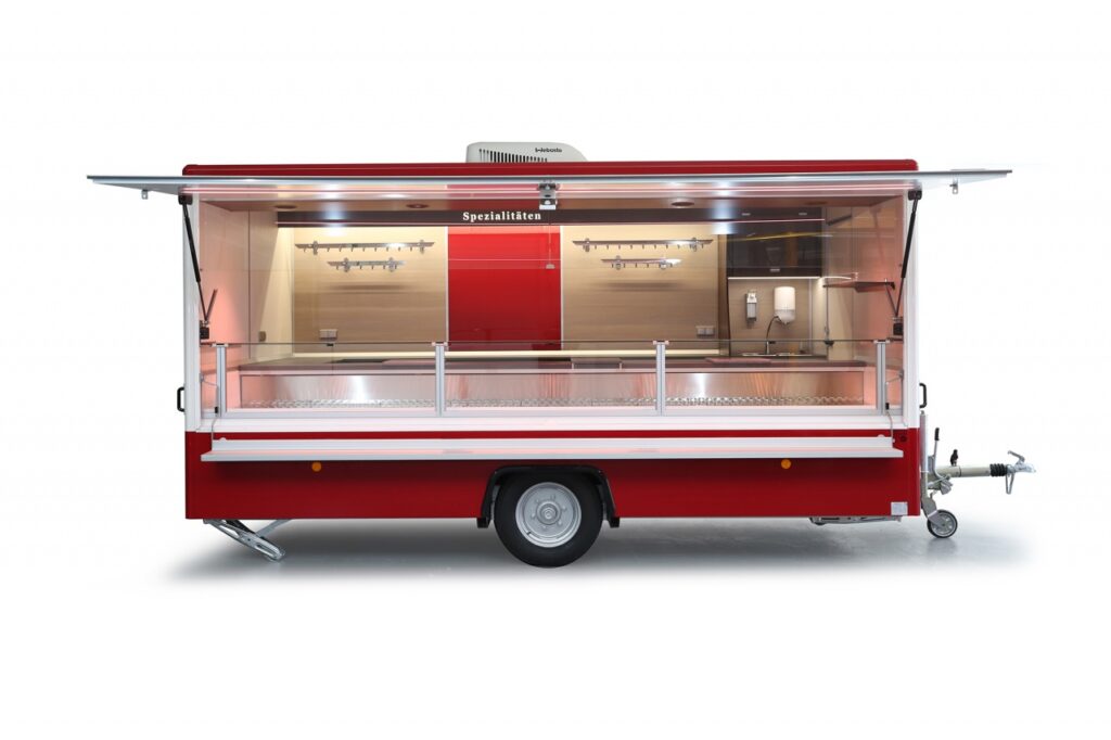 Verkaufsanhänger mit einer stillen Kühlung, ausgelegt auf eine Umgebungstemperatur von 32°C. Thekenauslage 740 mm mit senkrechtem Thekenaufsatz.-Klimaanlage auf dem Anhängerdach zum kühlen oder wärmen. Neuste LED-Beleuchtung abgestimmt auf Fleischwaren.