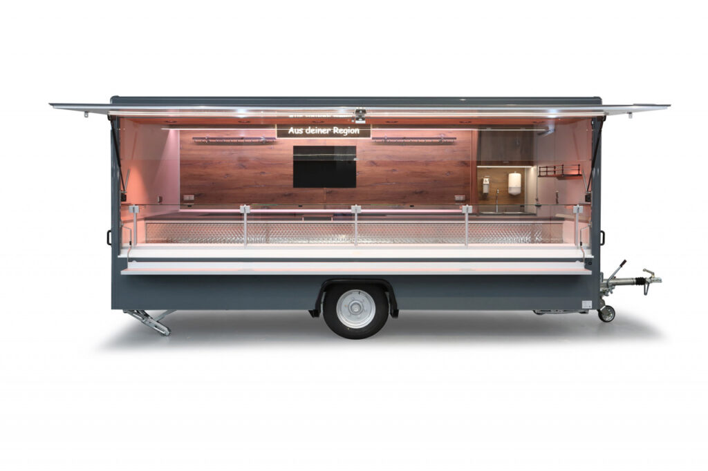 Verkaufsanhänger mit 5,00 m Verkaufskühltheke, unterhalb mit Doppelkühlfach für 4 E-Kisten.-Schalttafel 400 Volt, Hakenschienen, Werbetafel und Sensorik für Datenerfassung