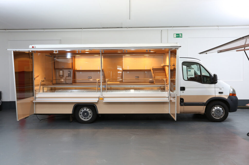 Käseverkaufsmobil mit 4,50 m Panorama-Kühltheke 740 mm Auslagentiefe, 2 Kühlfächer unter Theke, BÄRO-Strahler über Theke und Top-Light-Strahler an Verkaufsrückseite in Forming-Deckenlichtkasten, Käsetreppe mit separater Beleuchtung, verspiegelte Verdampferblende, Glas-Werbetafel uvm. -Beifahrer-Doppelsitzbank und  Rückfahrkamera. Gepflegter Zustand.