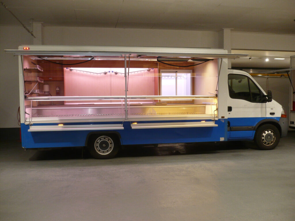 Wochenmarkt-Verkaufsmobil in geflegtem Zustand mit geringer Kilometerleistung.Kühlanlage für Kühltheke mit verstärkter Leistung, Sichtkühlschrank mit Schiebetüren an Verkaufsrückseite, Standheizung und beheizte Körperschutzkante vorhanden.