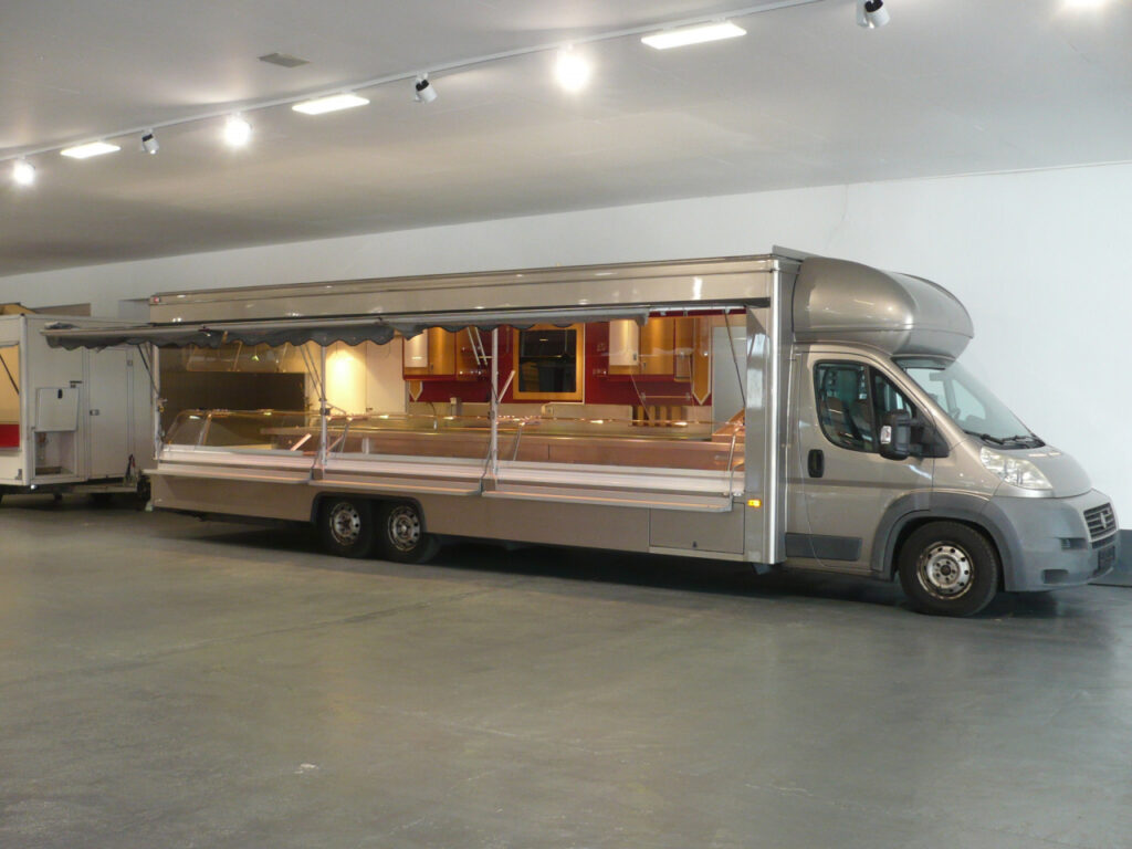 Fischverkaufsmobil mit 9,50m Kühltheke über Eck mit Leistungssteigerung, davon 5,00 m stille Kühlung, 4,50 m Kontaktkühlung, 3 Kühlfächer und 2 Kühlschränke von außen bestückbar.-Ausstattungsdetails: Gekühlte Schrägauslage, LCD-Rückfahrvideosystem, Unterflur Abwassertanks uvm.