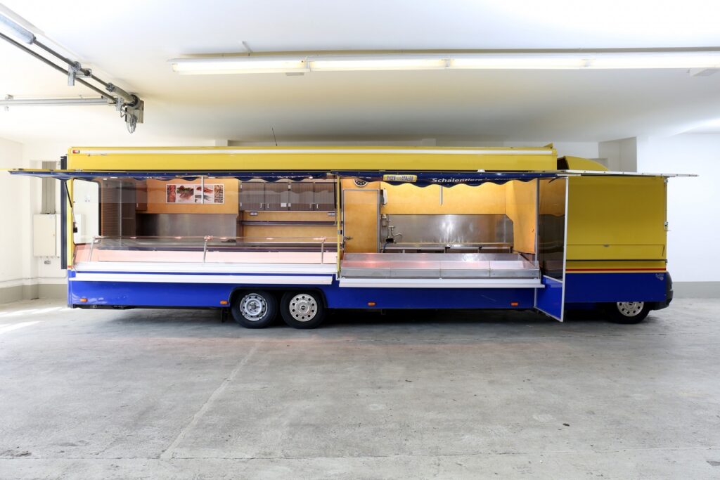 Fisch-Verkaufsmobil mit umfangreicher Ausstattung, 4,50 m Panorama-Kühltheke mit verstärkter Kühlleistung und Kühlraum unter der Theke, 3,00 m herausschiebbare Kontaktkühltheke aus Edelstahl, -Ausstattungsdetails: Fußbodenheizung, beheizbare Körperschutzkante, Rückfahrkamera, Verblendung vom Fahrerhaus uvm.