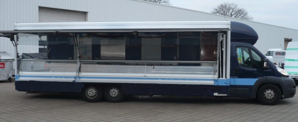 Sehr gut ausgestattetes Fisch-Verkaufsmobil für den Marktverkauf mit sehr geringer Kilometerleistung. Kühltheke mit verstärkter Leistung und Kontaktkühltheke über Eck mit kompletter Heckseite. verstärkte Kühlleistung mit beheizter Ablaufrinne, 3 Kühlfächer unter der Theke, große Kühltruhe mit Ladeklappe nach außen, Imbißanlage mit Bräter und Friteuse sowie Abzugshaube, 400 V Stromanschluß mit Kabeltrommel, Fahrerhausverblendung, Unterflur-Abwassertank, Glas-Werbetafeln uvm.