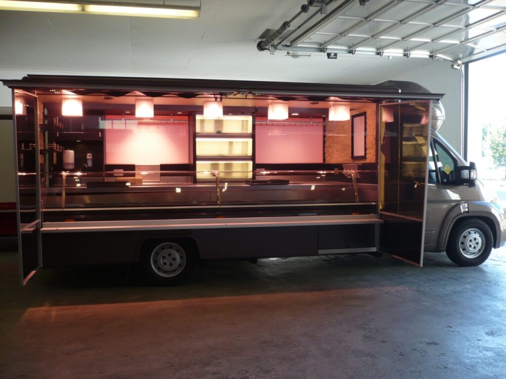 Kühlanlage mit verstärkter Leistung 32°, Kühlregal in 3 Etagen mit Rolladen, Bäro LED-Strahler mit eckigen Glasaufsätzen, 2 Kühlauszüge, -1 Kühlschrank mit 2 Auszügen, Dieselheizung, 2 Werbetafeln mit Glaschriftfeld und wechselndem LED-Farbspiel