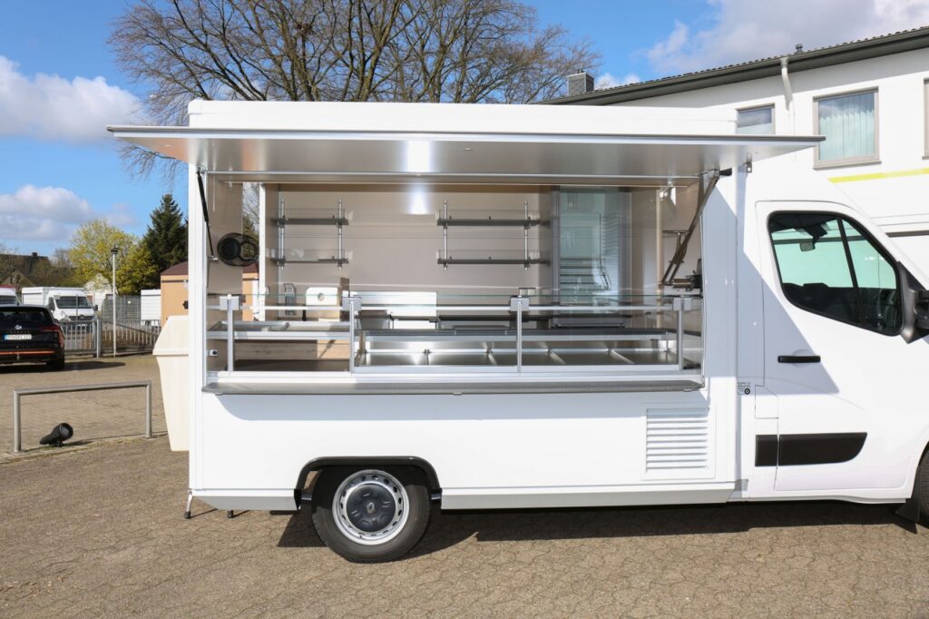 Hochwertiges Neufahrzeug mit elektrischer Klappenöffnung, einem Kuchenblechnachschubregal, einem LIEBHERR Kühlschrank, einer Lithium-Ionen-Antriebsbatterie sowie einer Ubert Bainmarie