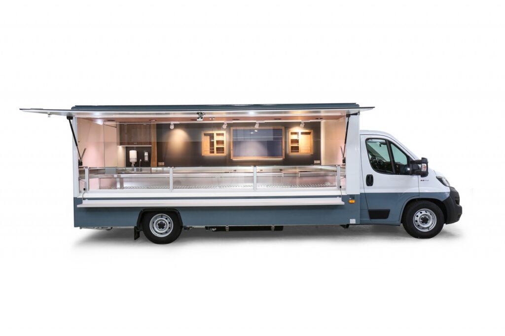 Das Fischverkaufsmobil ist mit unserer Optima Verkaufskühltheke ausgestattet. Die stille Kühlung ist auf 32 C° Grad Außentemperatur ausgelegt, die Auslagentiefe beträgt 740 mm, senkrechter Thekenaufsatz, 500 Liter Isoliertruhe, Doppelkühlfach unter der Theke mit einem Volumen von 400 Litern (4 x E-Kisten). Unterhalb des Fahrzeuges dient der Abwassertank zum auffangen des Thekenwassers. 400 Volt Stromanschluss. Durch modernste LED – Lichttechnik wird eine optimale Ausleuchtung der Ware gewährleistet. Die Rückwand ist bestückt mit einer großen Glaswerbetafel und zwei Regalen für eine optimale Warenpräsentation. Das Basisfahrzeug FIAT hat 140 PS, Ganzjahresreifen, DAB Radio, autom. Ein-Zonen-Klimaanlage, Beifahrerdoppelsitzbank, LED-Schluss- und Umrissleuchten.