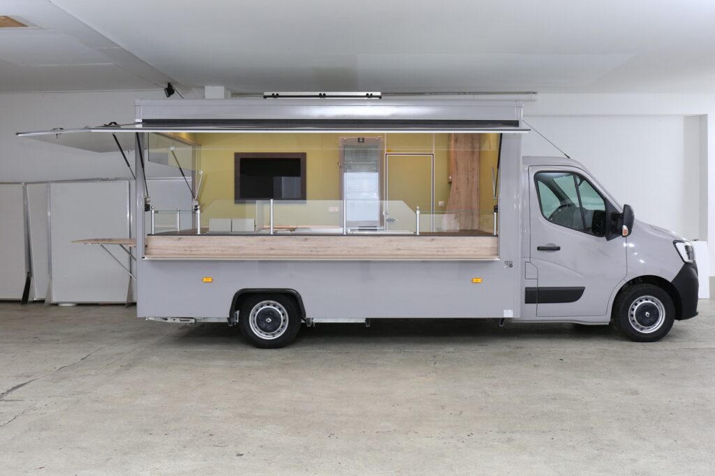 Imbiss Verkaufsfahrzeug-4,00 m Innenlänge mit zwei Verkaufsseiten. Im Heck einen Esstisch und Ausgabestelle.-Bainmarie, Rostgrill mit Schaschlikpfanne und Doppel-Freitteuse ermöglichen ein gutes Zubereiten von Speisen.-Vorratsmöglichkeit in Kühlschränken und im Warenregal.-Glasschrift-Werbetafel.-Basisfahrzeug Renault Master, 135 PS mit Allwetterbereifung