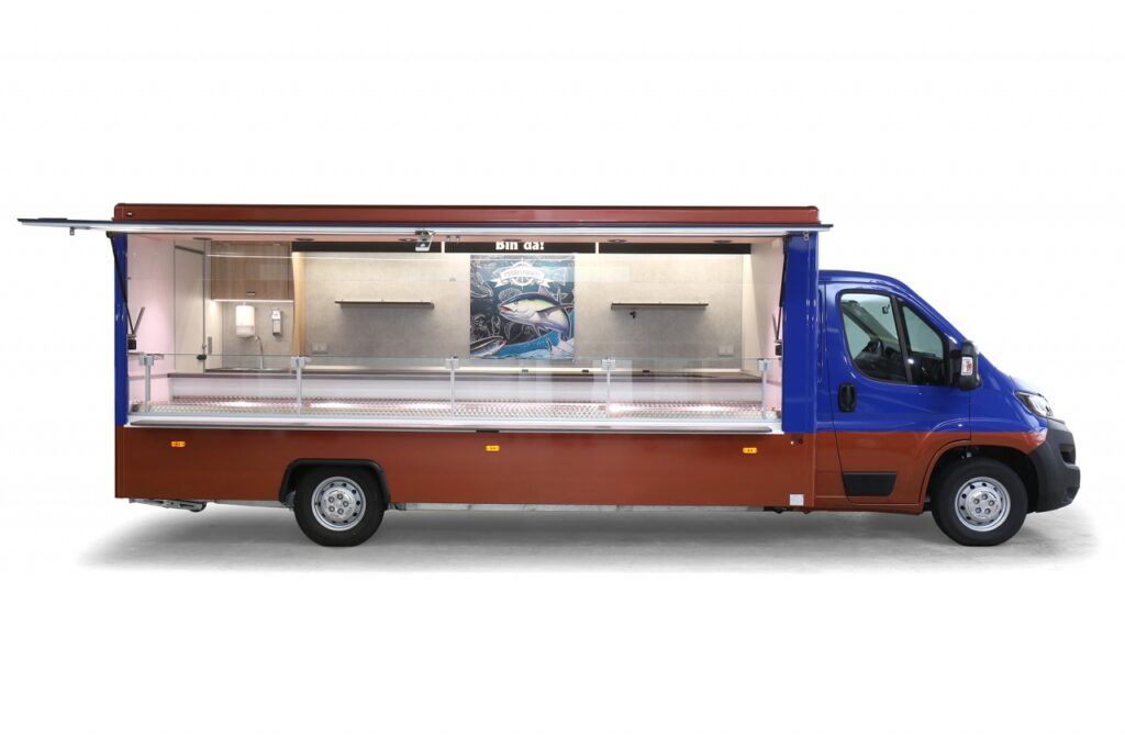 Das Fischverkaufsmobil ist mit unserer Maxima Top Verkaufskühltheke ausgestattet. Die stille Kühlung ist auf 32 C° Grad Außentemperatur ausgelegt, die Auslagentiefe beträgt 745 mm, senkrechter Thekenaufsatz. 500 Liter Truhe, Fußbodenbelag Polyster, 230 Volt Stromanschluss. Durch modernste LED – Lichttechnik wird eine optimale Ausleuchtung der Ware gewährleistet. Das Basisfahrzeug FIAT hat 120 PS, Ganzjahresreifen,, LED-Schluss- und Umrissleuchten.