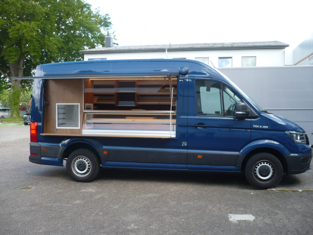 Das Verkaufsfahrzeug ist mit einer Backwarentheke und anschließendem Sichtkühlschrank ausgestattet, der Thekenaufsatz ist ein radialer Hebelbeschlag. Neuste LED-Lichttechnik mit hoher Lichtleistung, die Brotborde haben Silber-Rundstäben und gehen über 3 Etagen an der Rückwand, unter der hinteren Arbeitsfläche ist Platz für 5 Nachschub - Kuchenbleche; Durchgang zum Fahrerhaus mit einer verschließbaren Drehtür, Läutewerk, Lithium-Ionen-Antriebsbatterie-Technik,MAN TGE 2.100 4X2F/SB, Reflektor Folienstreifen an der Verkaufsklappe. Basisfahrzeug MAN, Einzelsitz, Allwetterbereifung, Radio, Trittstufe über die gesamte Breite.