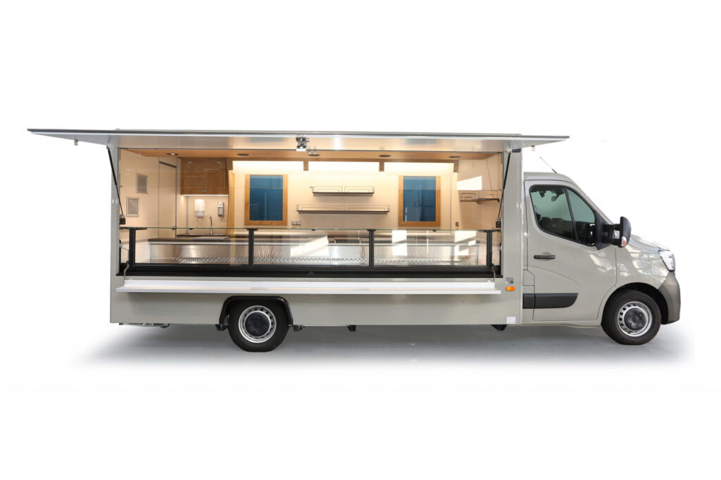 Verkaufsmobil für Feinkost-Kühltheke mit 740 mm Auslage und stiller Kühlung, unterhalb 3 Kühlfächer für 6 E-Kisten.-Regale und Werbetafel für Ihre Warenpräsentation-senkrechter Thekenaufsatz in modernem schwarz-Stromanschluss 400 Volt, LCD-Rückfahrvideosystem-Renault Master mit Klang- und Klima-Paket