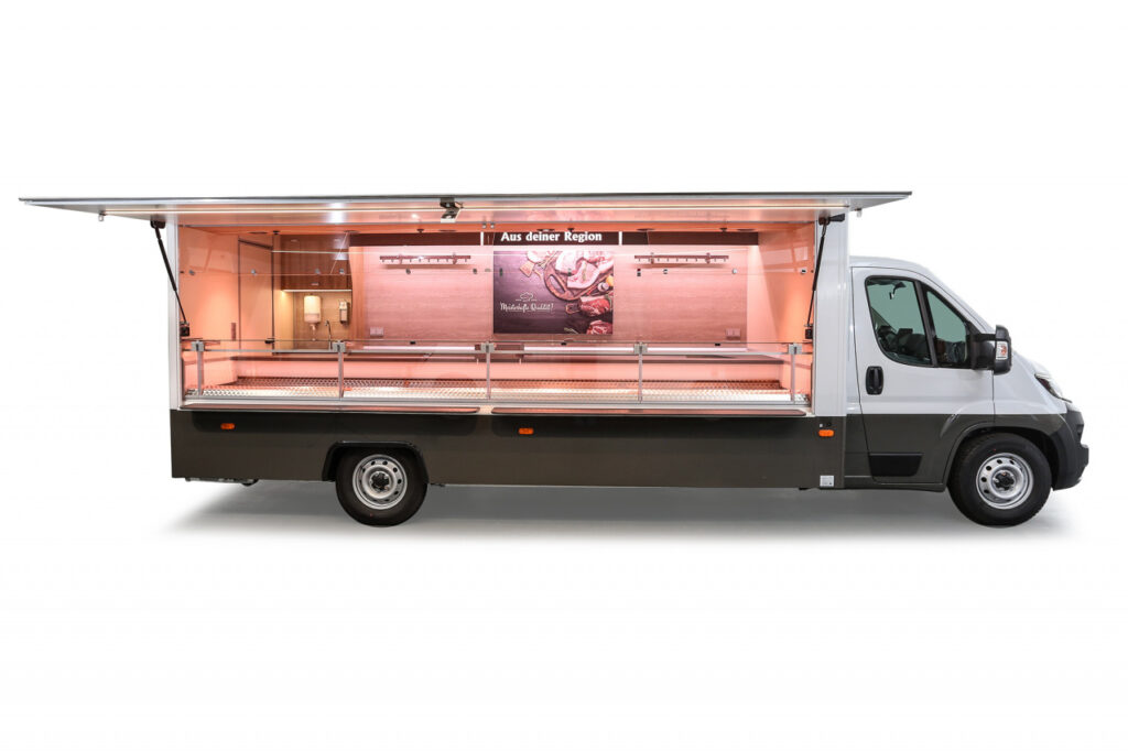 Fleisch- und Wurstwaren Verkaufsmobil-5m Kühltheke mit Umluftkühlung und 3 Kühlauszügen.-austauschbarer Werberahmen, Regale-Fiat Ducato mit Allwetterbereifung, automatischer Klimaanlage und Doppelsitzbank