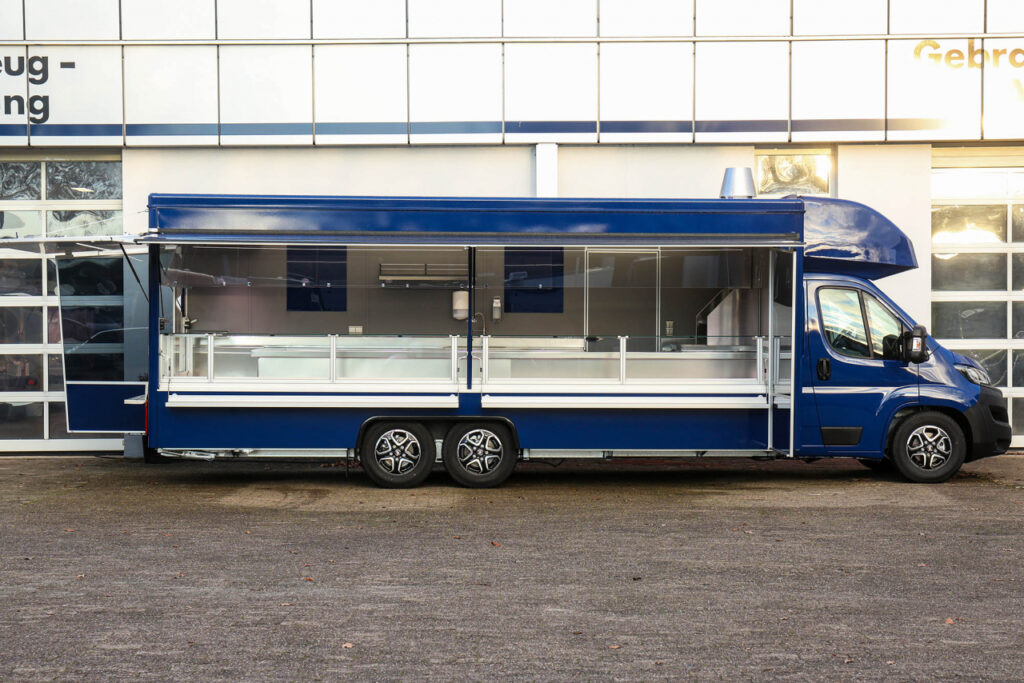 Verkaufsmobil für den Wochenmarkt mit Ecktheke-Kühltheke über Eck für Kontaktkühlung, Kühlauszüge unter der Theke für 6 E-Kisten, Einbauspüle, -HEWIGO Friteuse (gasbetrieben), Warmluftheizung uvm.-Fiat Ducato mit Leichtmetallfelgen, Allwetterbereifung, Automatikgetriebe und Infotainmentsystem